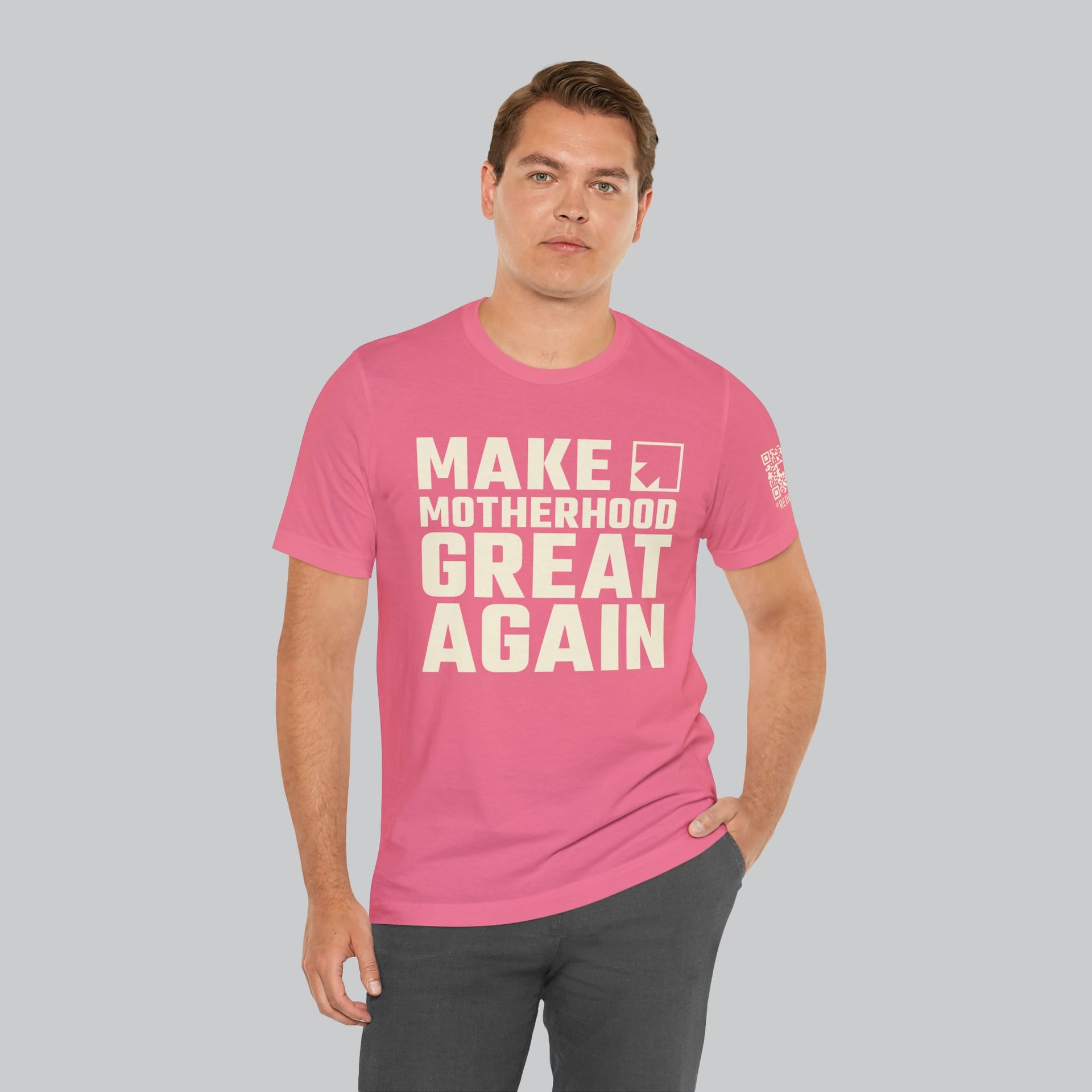 Image of man wearing pink color t shirt back with saying "make motherhood great again" in white text with REDGlare arrow logo celebrating motherhood and not wokeness